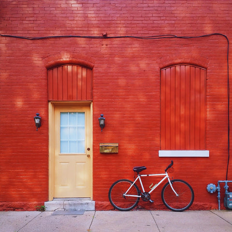 Red Wall with a Bicycle by Sina Irani
